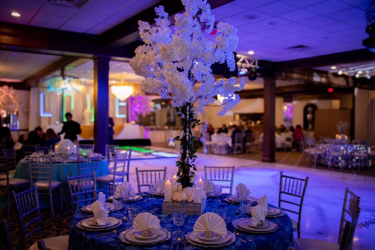 Árbol de flores blanco como centro de mesa sobre mantel azul