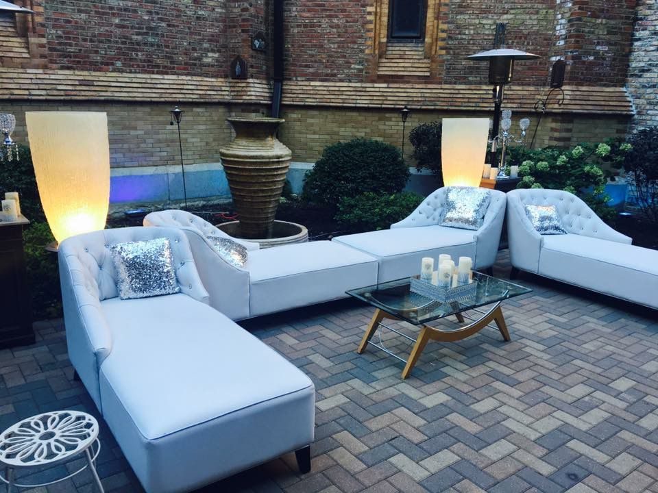 Lounge blanco montado en patio con calentadores y velas