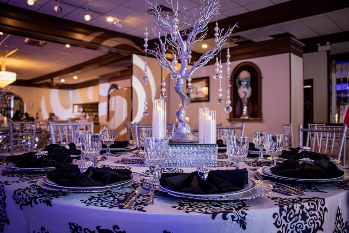 Mesa en damasco blanco y negro con árbol plateado y velas