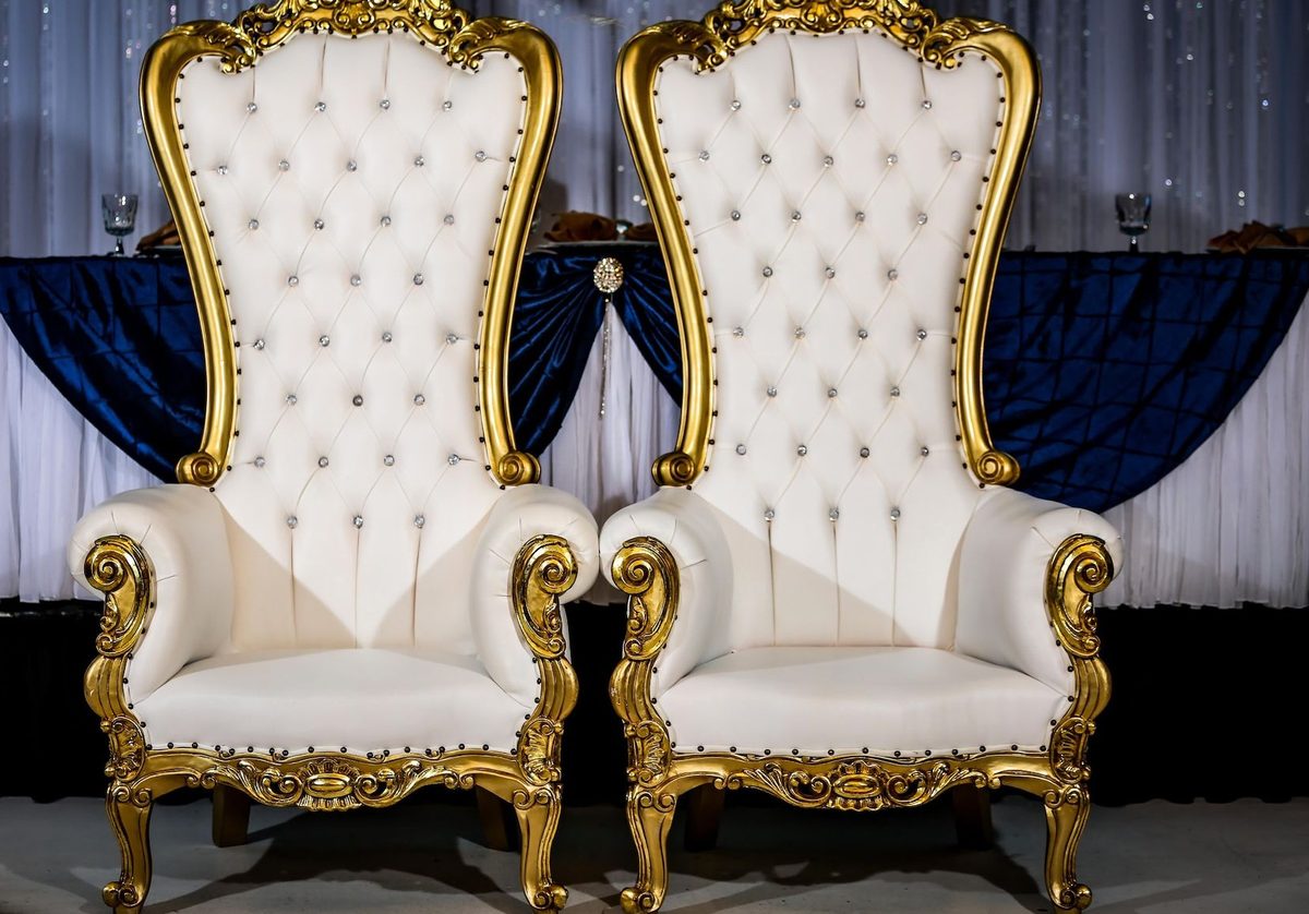 Sillas trono doradas frente a mesa principal en azul marino