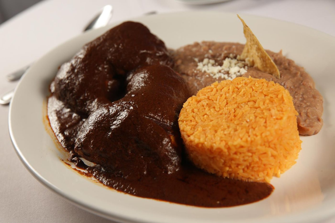 Pollo en mole rojo con arroz y frijoles